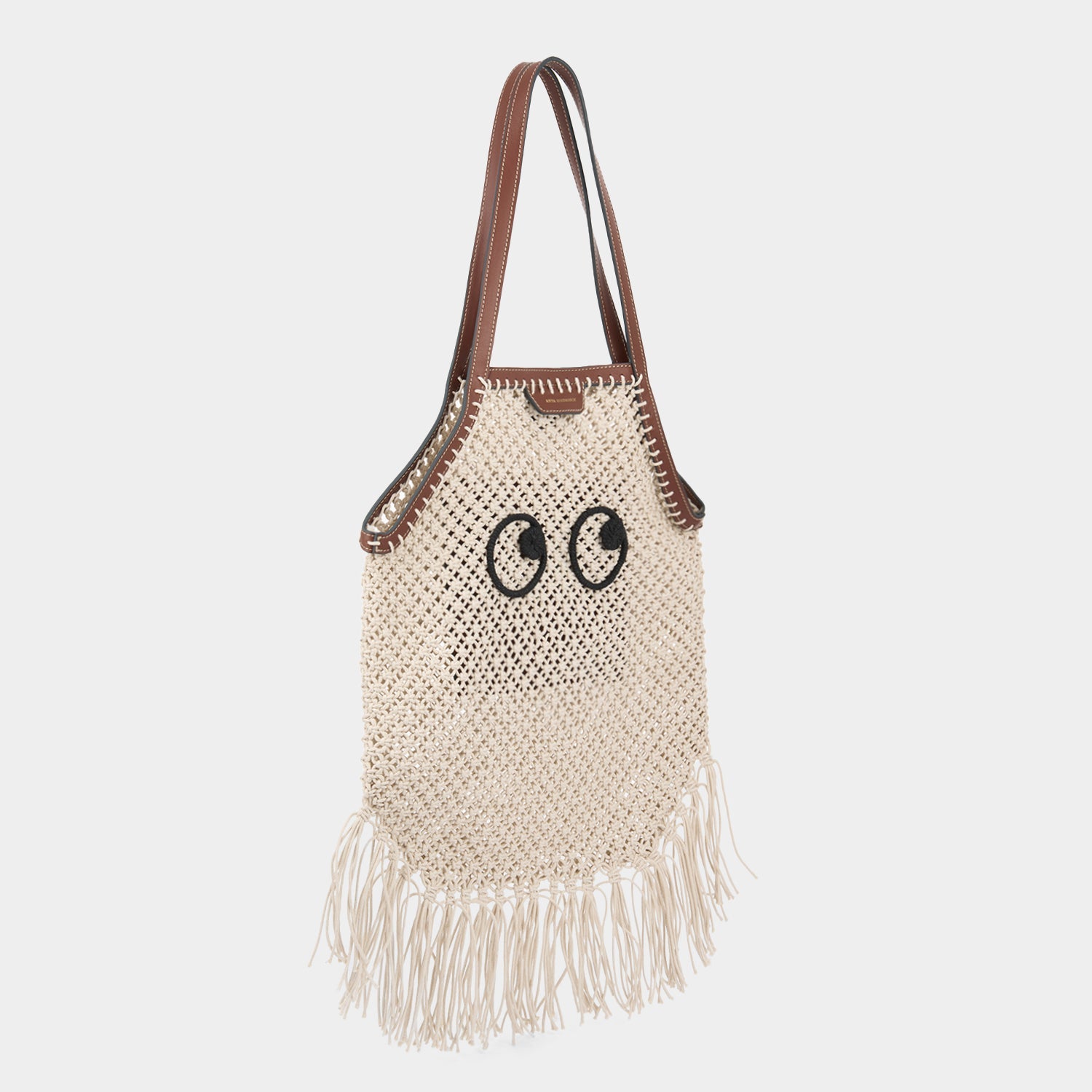 Macramé tote bag handcrafted from natural cotton cord and embroidered Eyes motif with eco-leather top handles and detachable long crossbody strap by Anya Hindmarch