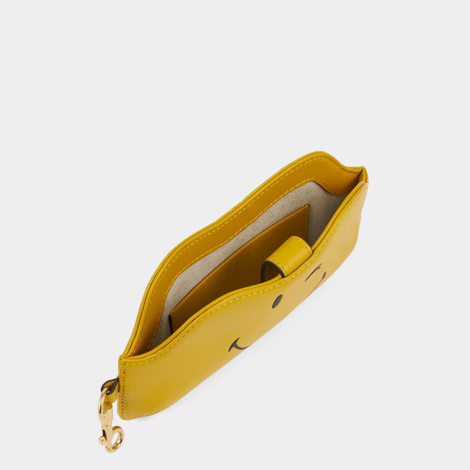 Yellow leather sunglasses holder with winky face by Anya Hindmarch